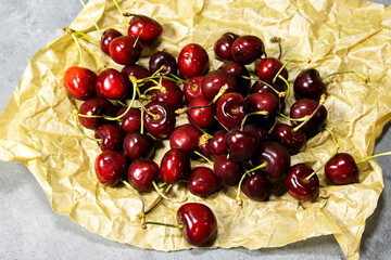 Fresh cherry fruit in crash paper on wooden table