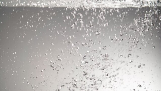 Filling containers with water. Bubbles under clear water. Fluid movement. Close-up.