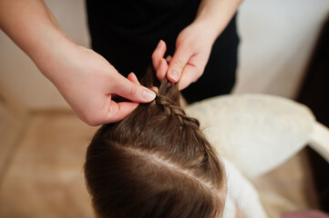 Fototapeta premium Mother and daughter weekend together at home, mom making hairstyle.