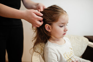Naklejka premium Mother and daughter weekend together at home, mom making hairstyle.