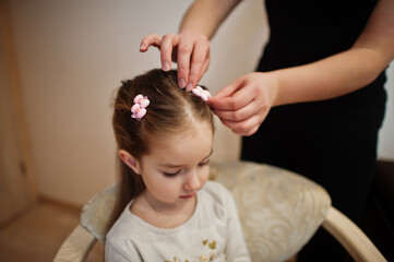 Fototapeta premium Mother and daughter weekend together at home, mom making hairstyle.