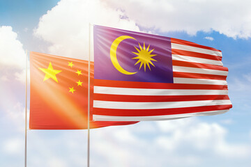 Sunny blue sky and flags of malaysia and china