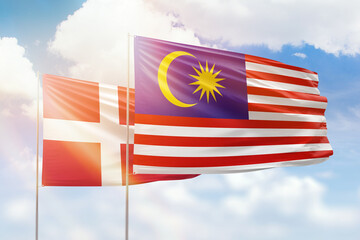 Sunny blue sky and flags of malaysia and denmark