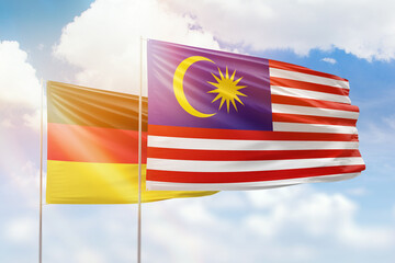 Sunny blue sky and flags of malaysia and germany