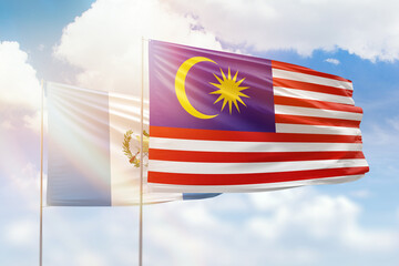 Sunny blue sky and flags of malaysia and guatemala