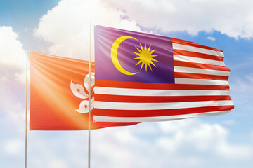 Sunny blue sky and flags of malaysia and hong kong