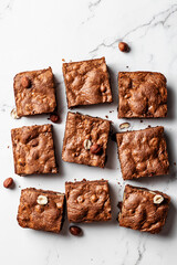 Chocolate brownies with hazelnuts on marble background, flat lay composition