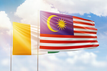Sunny blue sky and flags of malaysia and ivory coast