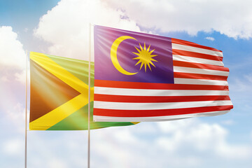 Sunny blue sky and flags of malaysia and jamaica
