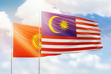 Sunny blue sky and flags of malaysia and kyrgyzstan