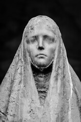 Il volto della statua di una donna dolente su una tomba del cimitero monumentale di Milano