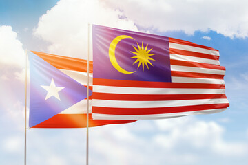 Sunny blue sky and flags of malaysia and puerto rico