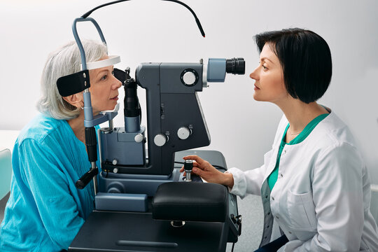 Senior Woman Getting Eye Exam At Ophthalmology Clinic With Optometrist. Ophthalmology For Older People