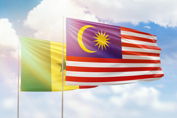 Sunny blue sky and flags of malaysia and senegal