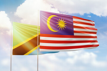 Sunny blue sky and flags of malaysia and tanzania