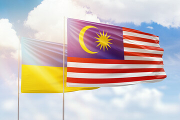 Sunny blue sky and flags of malaysia and ukraine