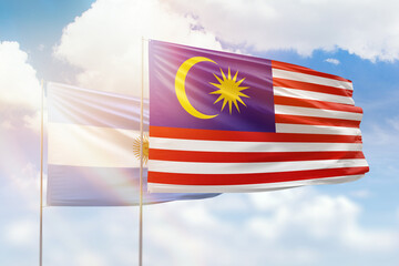Sunny blue sky and flags of malaysia and argentina
