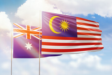 Sunny blue sky and flags of malaysia and australia