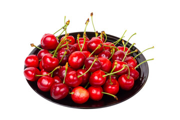 Naklejka na ściany i meble Sweet cherry on a black plate. Sweet cherry isolated on white background.