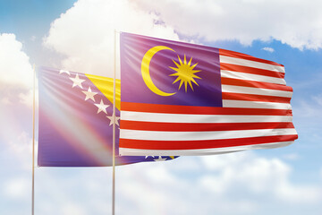 Sunny blue sky and flags of malaysia and bosnia