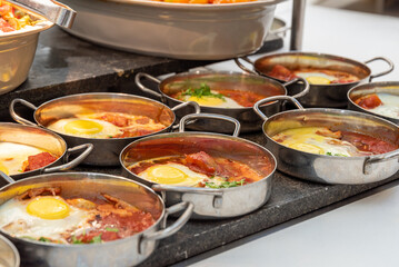 Typical Israeli breakfast buffet at any hotel. Close up of single servings of shakshuka a...