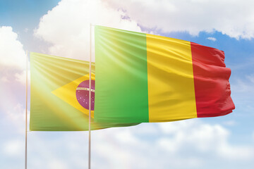 Sunny blue sky and flags of mali and brazil