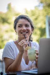 Portrait of a young smiling woman drinking juice cocktail