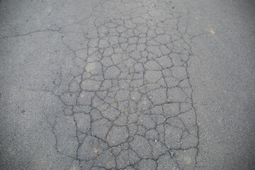 Asphalt with cracks radiating across the surface