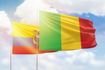 Sunny blue sky and flags of mali and ecuador