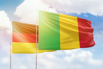 Sunny blue sky and flags of mali and germany