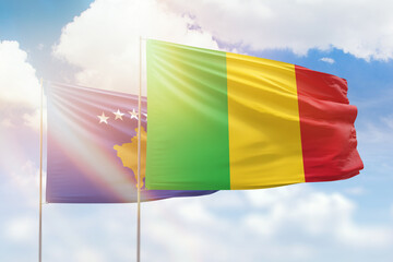 Sunny blue sky and flags of mali and kosovo