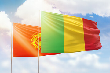 Sunny blue sky and flags of mali and kyrgyzstan