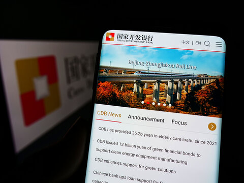 Stuttgart, Germany - 06-12-2022: Person holding smartphone with logo of China Development Bank (CDB) on screen in front of website. Focus on phone display.