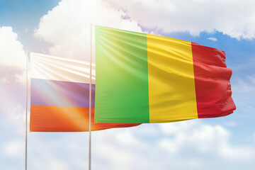 Sunny blue sky and flags of mali and russia