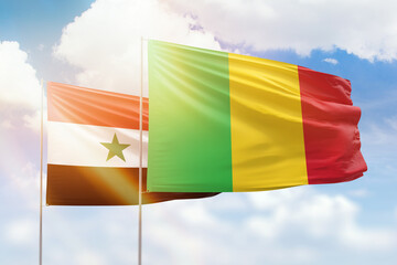 Sunny blue sky and flags of mali and syria