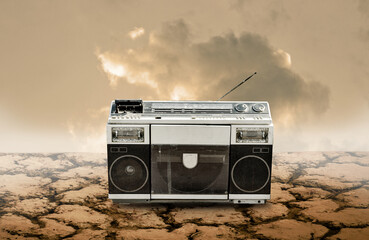 Vintage radio and cassette player on cracked earth, Technology in wilderness