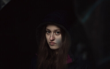 Dark portrait of a woman in hood