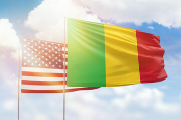 Sunny blue sky and flags of mali and usa