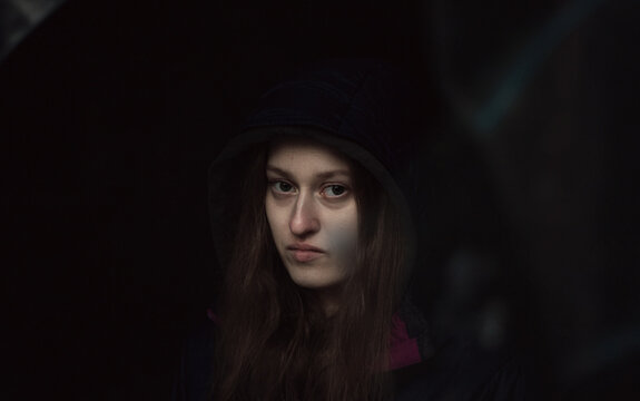 Dark portrait of a woman in hood