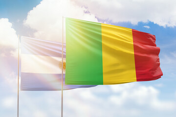 Sunny blue sky and flags of mali and argentina