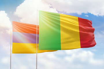 Sunny blue sky and flags of mali and armenia