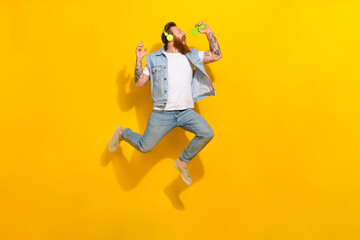 Fototapeta na wymiar Full body portrait of overjoyed energetic person hold phone sing jump isolated on yellow color background