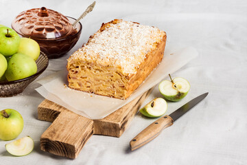 Apple and coconut loaf cake on wooden cutting board