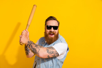 Photo of strong excited man wear jeans waistcoat dark eyewear playing baseball isolated yellow color background - obrazy, fototapety, plakaty