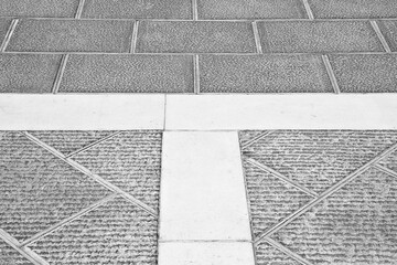 Fototapeta premium New carved paving made with chiseled grey sandstone blocks in a pedestrian zone