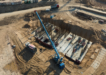 Сonstruction site, aerial view. Monolithic slab foundation and concrete pouring. Mobile auto Crane on formworks. Preparing Formwork for First Floor Slab on building сonstruction. .