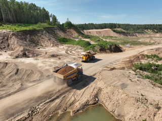 Mining excavator loads sand into dump truck. Excavator loads sand rock into a haul truck. Sand pit development. Mining industry. Electric rope shovel dropping rock ore. Sand mining in opencast.