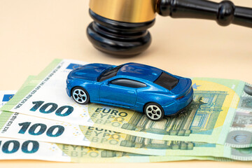 Gavel of judge, car model and 100 euro banknotes on the table in court, concept picture