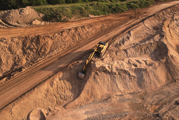 Excavator dig ground at construction site. Earthmover  on road construction. Heavy equipment and machinery. Backhoe on earthwork. Open pit development and sand extraction. Mining industry Reserves.