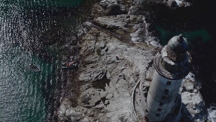 Lone lighthouse located near to ocean coast with rocks water shot by drone aerial view background theme above ground amazing picture masterpiece nature building architecture perfect 